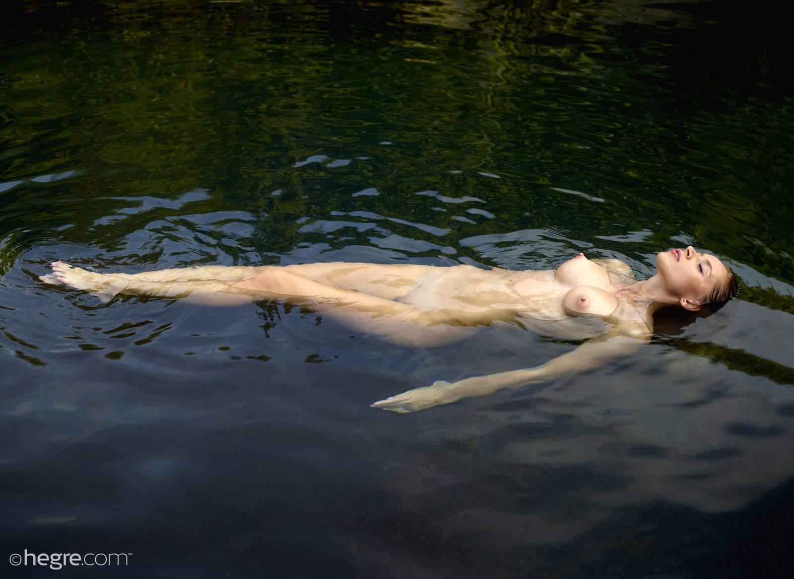Голая девушка плавает в воде - фото.